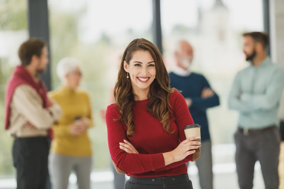 Une conseillère souriante, son équipe en arrière-plan
