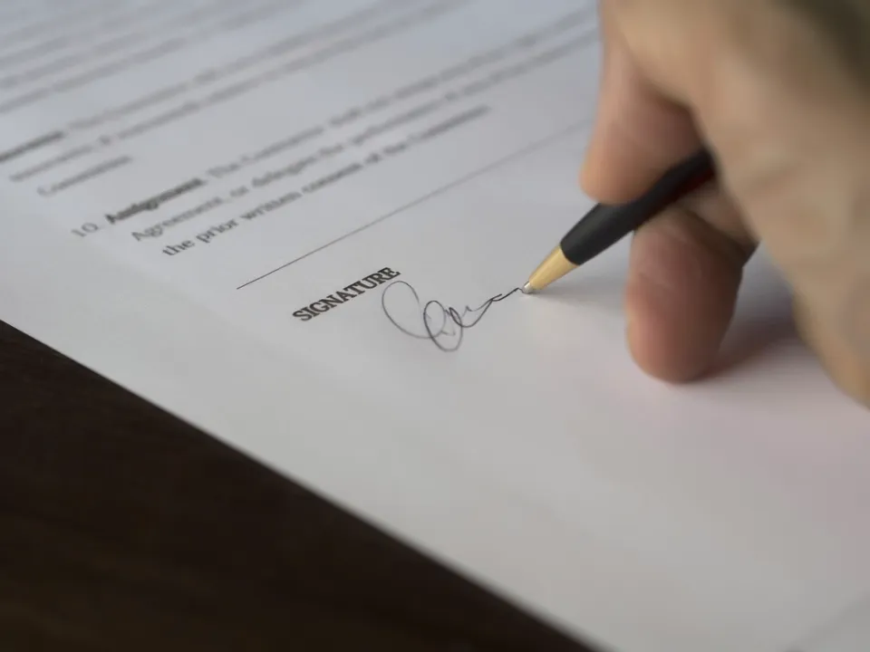 Une main signant un contrat au stylo